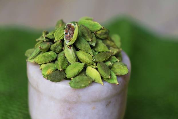 Closeup of a cardamon pod with white and green background