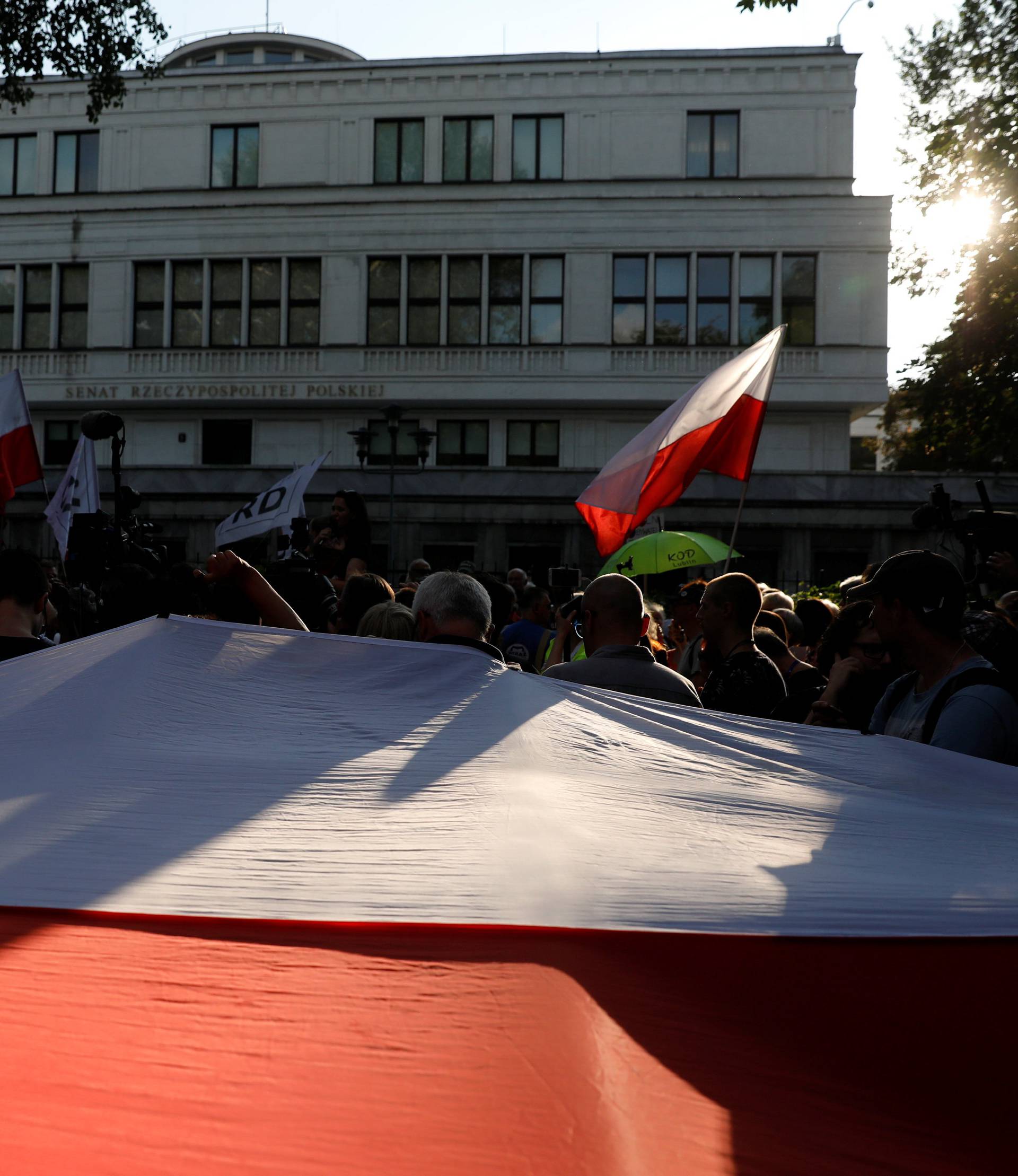 People gather during an anti-government protest in support of free courts in front of the the Senate building in Warsaw