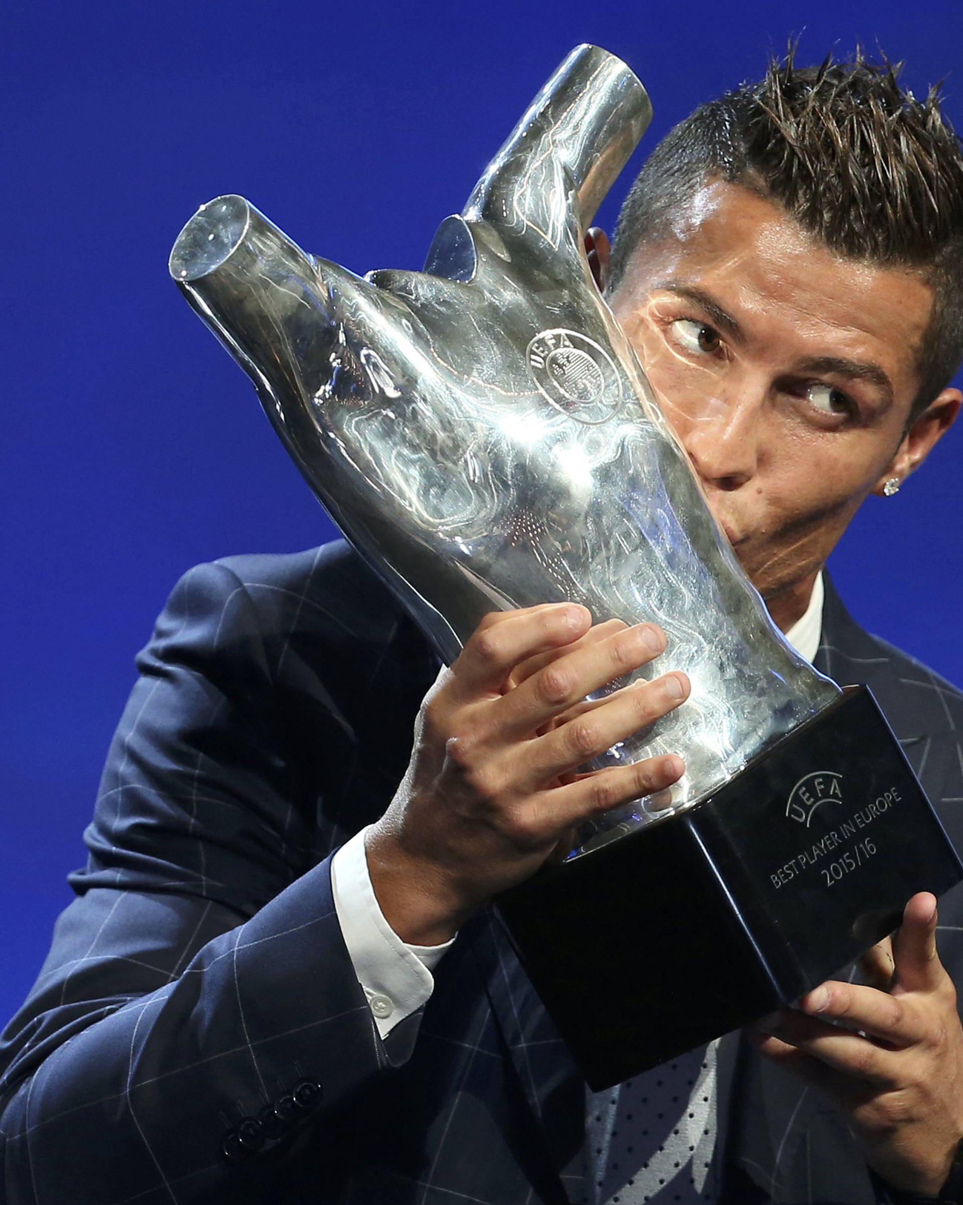 Real Madrid's Cristiano Ronaldo of Portugal kisses the Best Player UEFA 2015/16 Award during the draw ceremony for the 2016/2017 Champions League Cup soccer competition at Monaco's Grimaldi in Monaco
