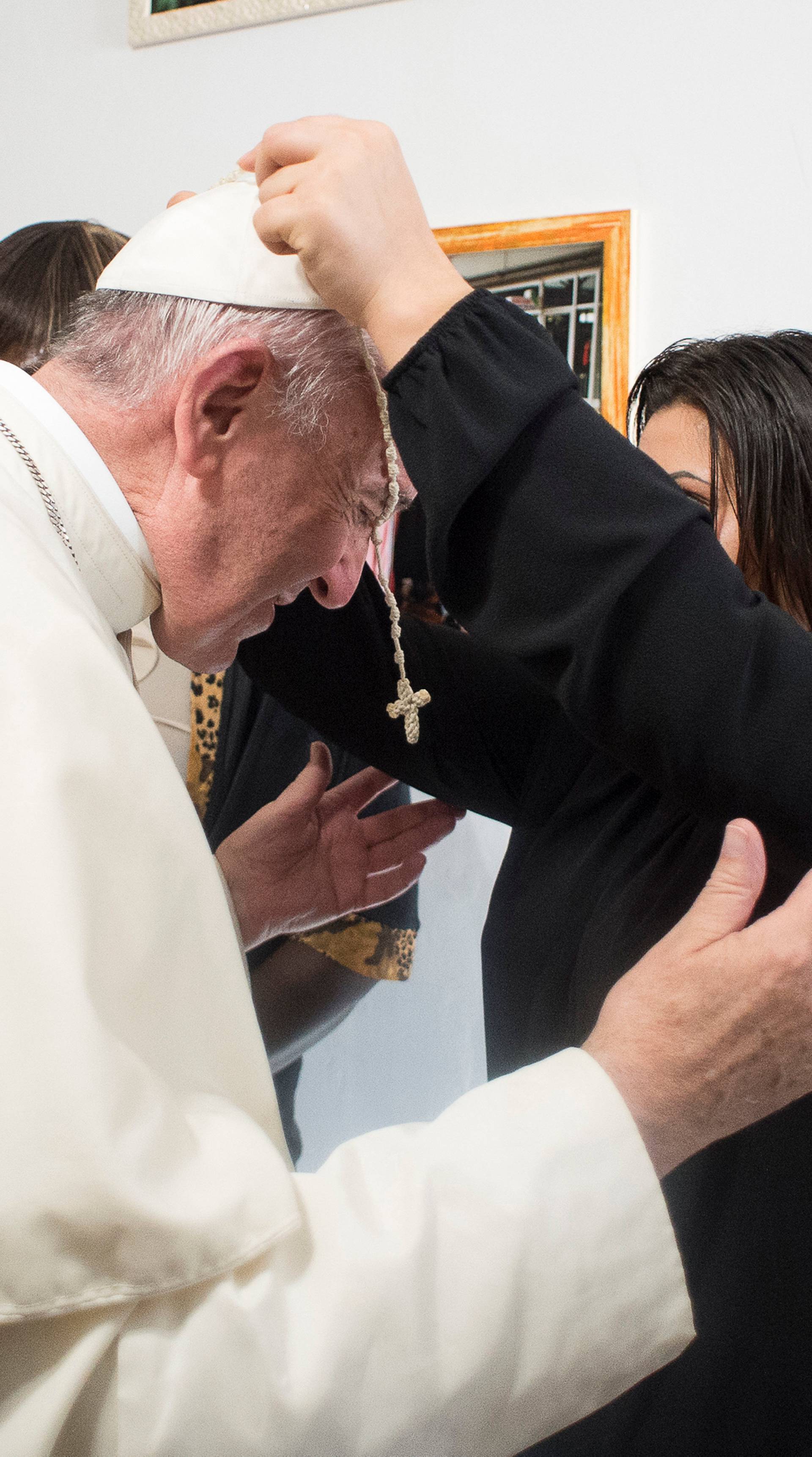 Pope Francis receives a crucifix as a gift from a member of the Pope John XXIII community in Rome