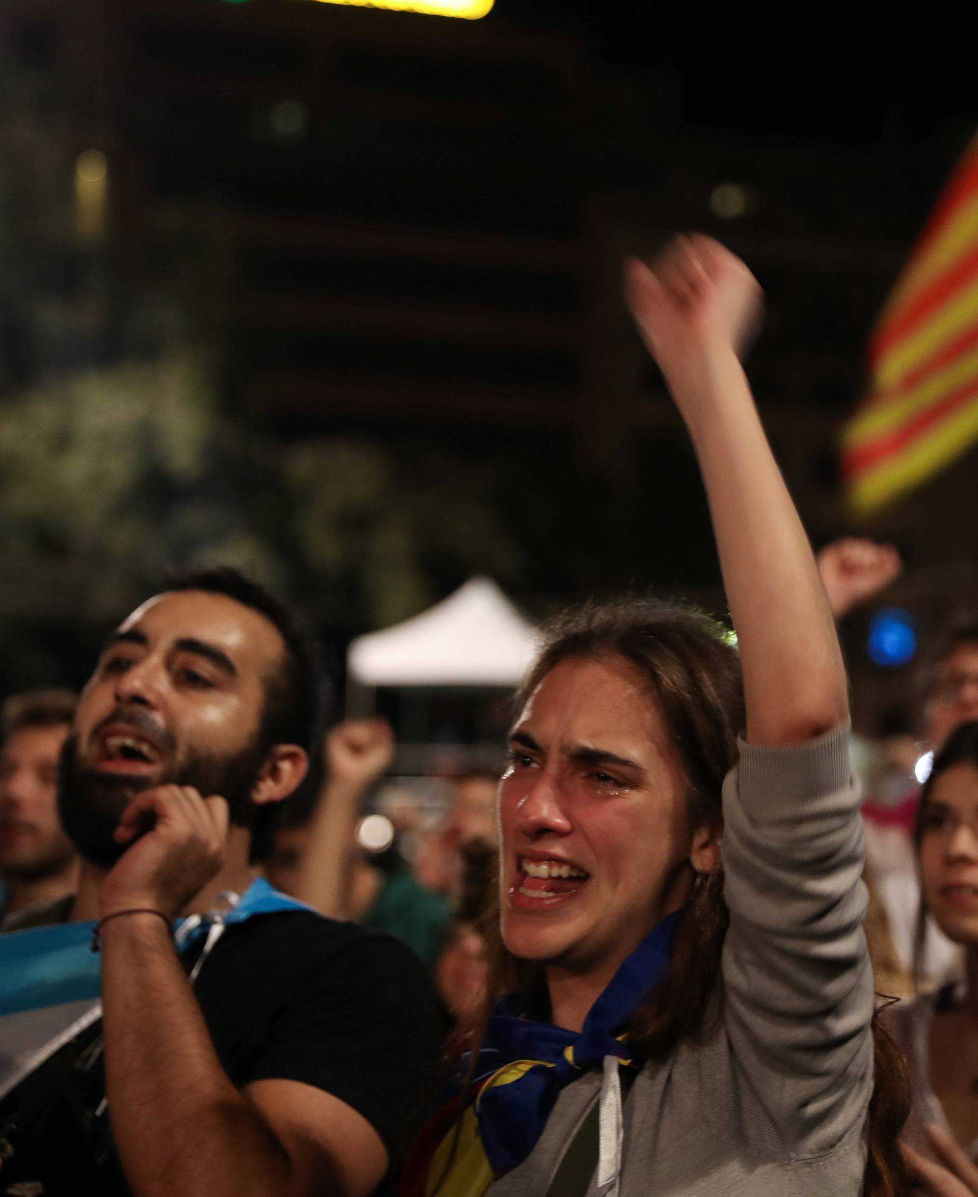 People react as they listen to Catalan president Carles Puigdemont during a gathering at Plaza Catalunya after voting ended for the banned independence referendum, in Barcelona