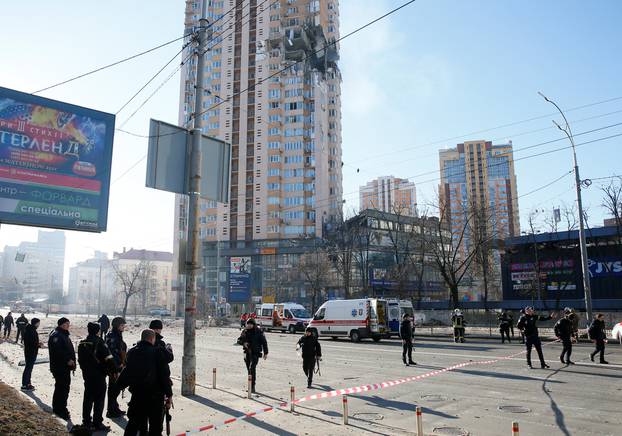 Members of emergency services work near an apartment building damaged by recent shelling in Kyiv