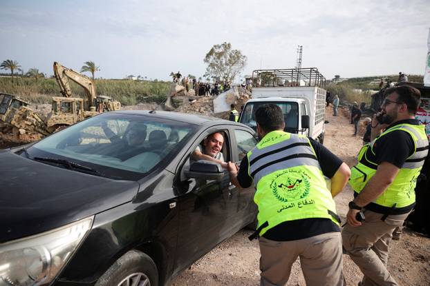 Displaced people cross the bridge linking southern Lebanon to the rest of the country, which was hit earlier in an Israeli strike, in Qasmiyeh