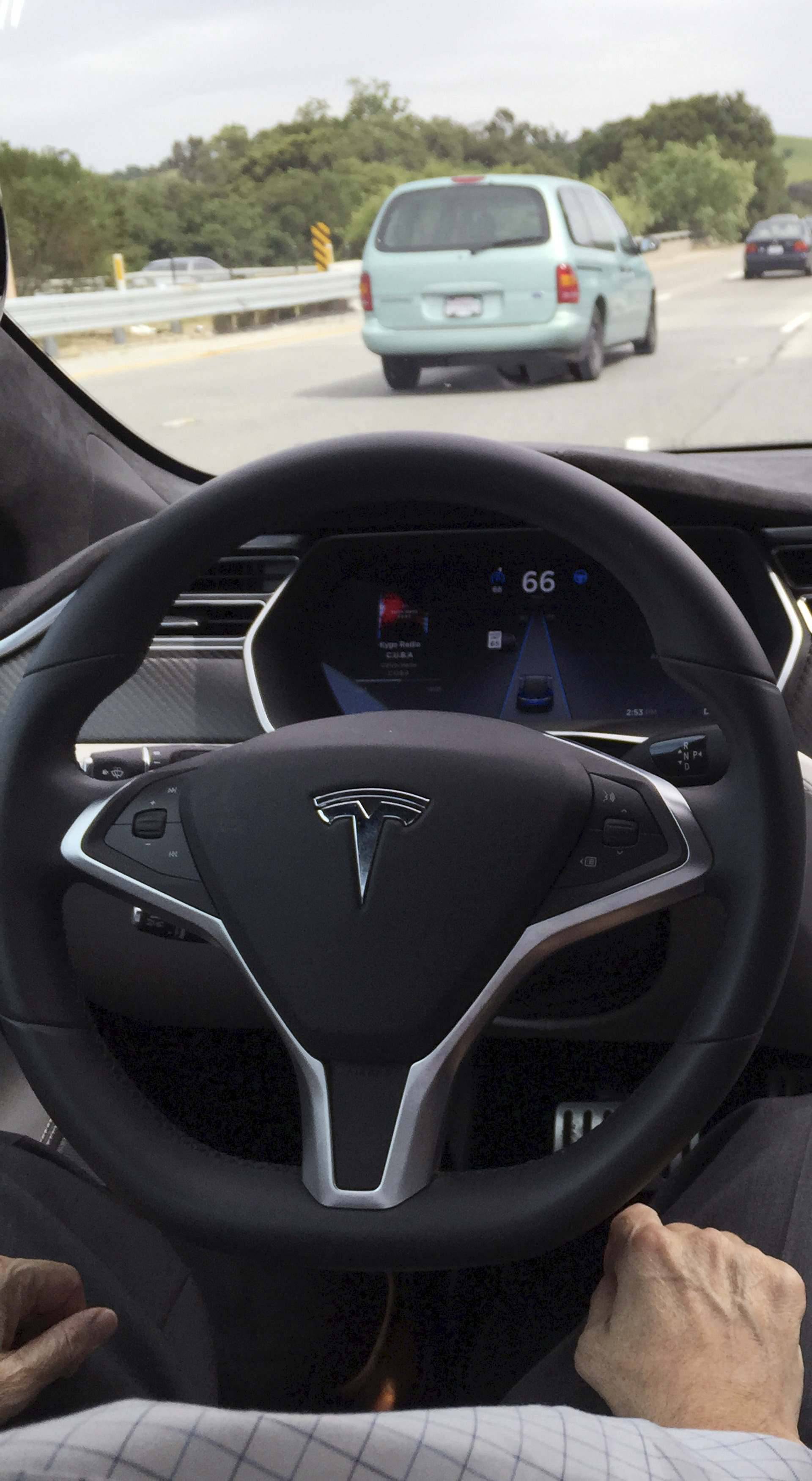 The interior of a Tesla Model S is shown in autopilot mode in San Francisco