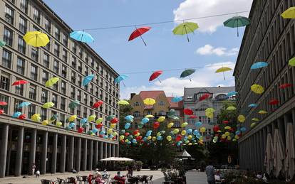 Coloured umbrellas are hanging on ropes over a square to advertise an upcoming wine festival at Berlin's Charlottenburg district in Berlin