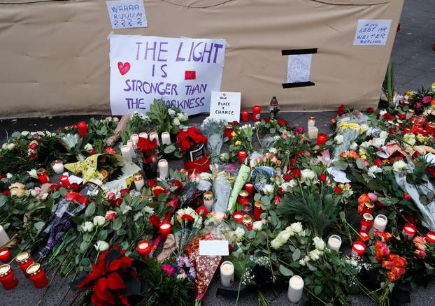 Flowers and posters are placed at the scene where a truck ploughed into a crowded Christmas market in the German capital last night in Berlin