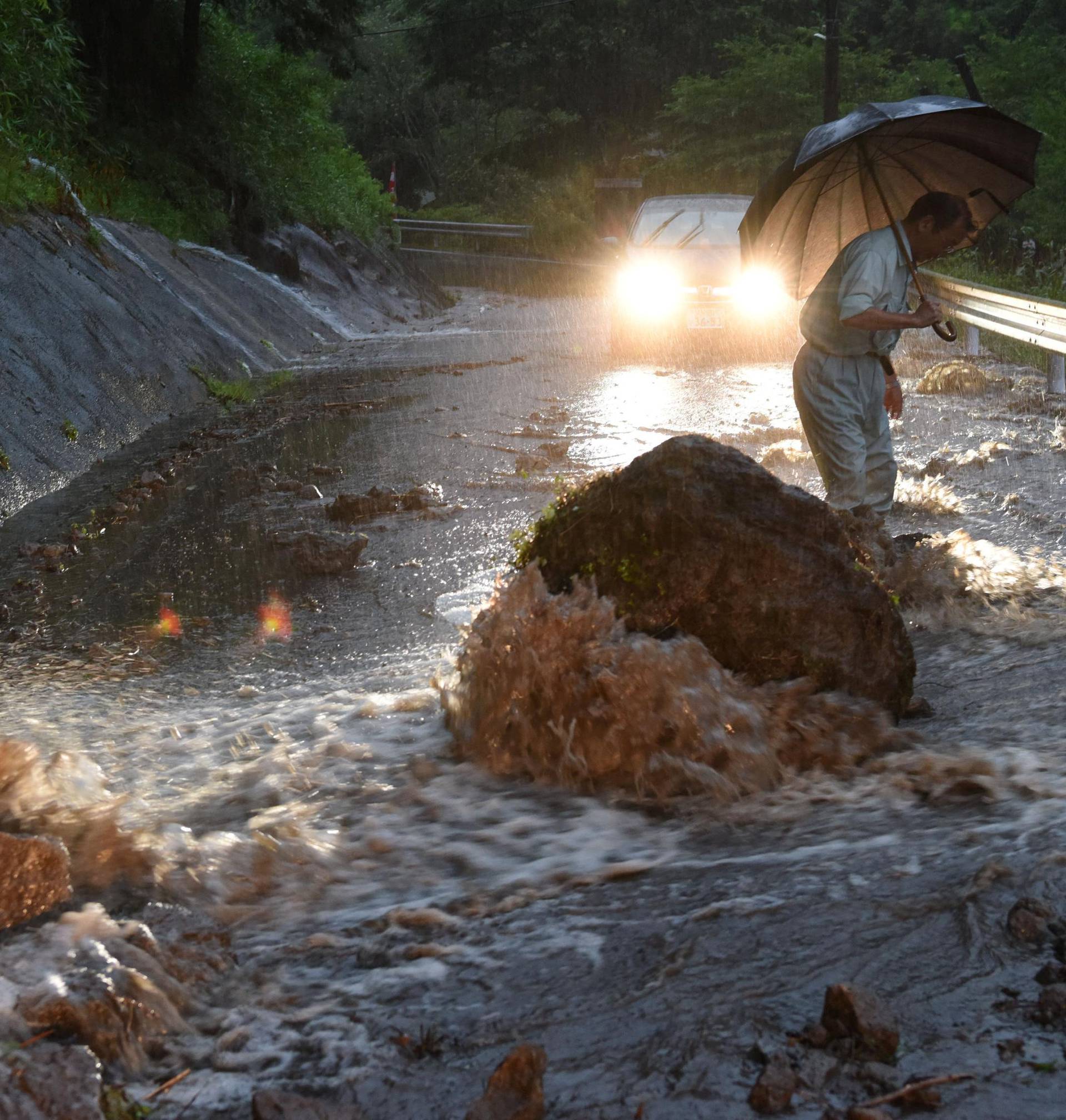 A flooded road with fallen rocks is pictured in Hita in Oita Prefecture, southwestern Japan