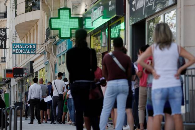 FILE PHOTO: People queue to enter a laboratory to get tested for the coronavirus disease (COVID-19) in Neuilly-sur-Seine, near Paris