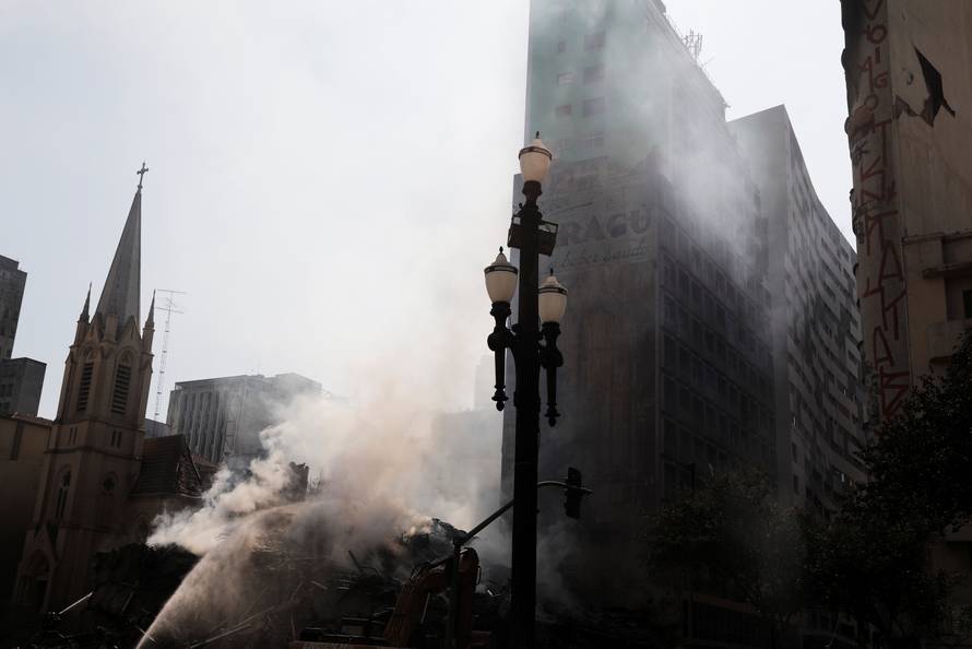 Firefighters try to extinguish the fire of a building that caught fire and collapsed in the center of Sao Paulo