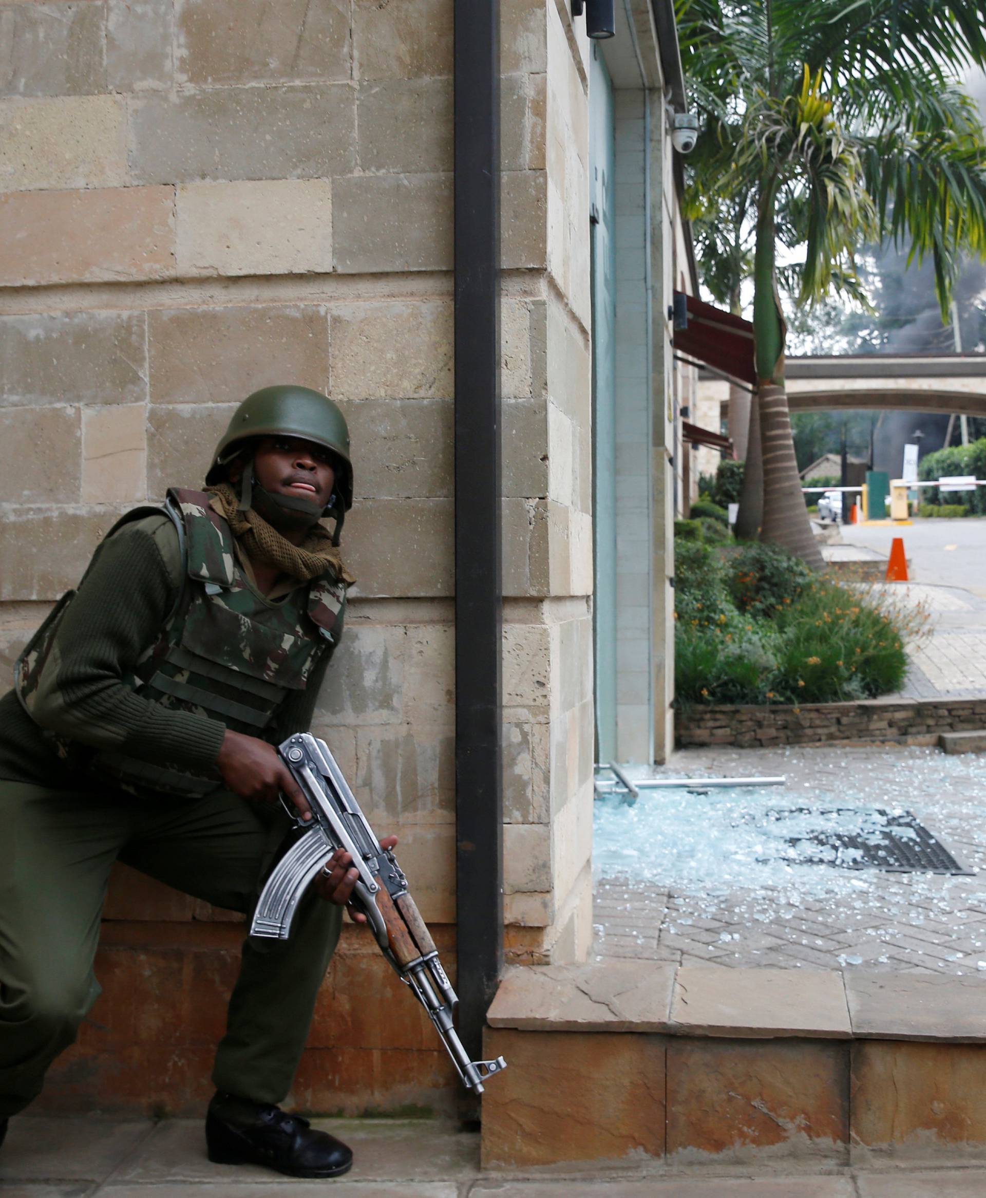 A policeman takes position at the scene where explosions and gunshots were heard at the Dusit hotel compound, in Nairobi