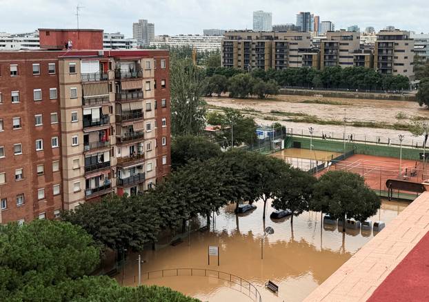 People look at the flooded playground near Besos river in Sant Adria de Besos on the outskirts of Barcelona