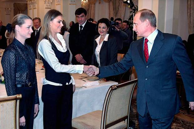 Alina Kabaeva shakes hands with Vladimir Putin during a meeting with gymnasts in Kremlin