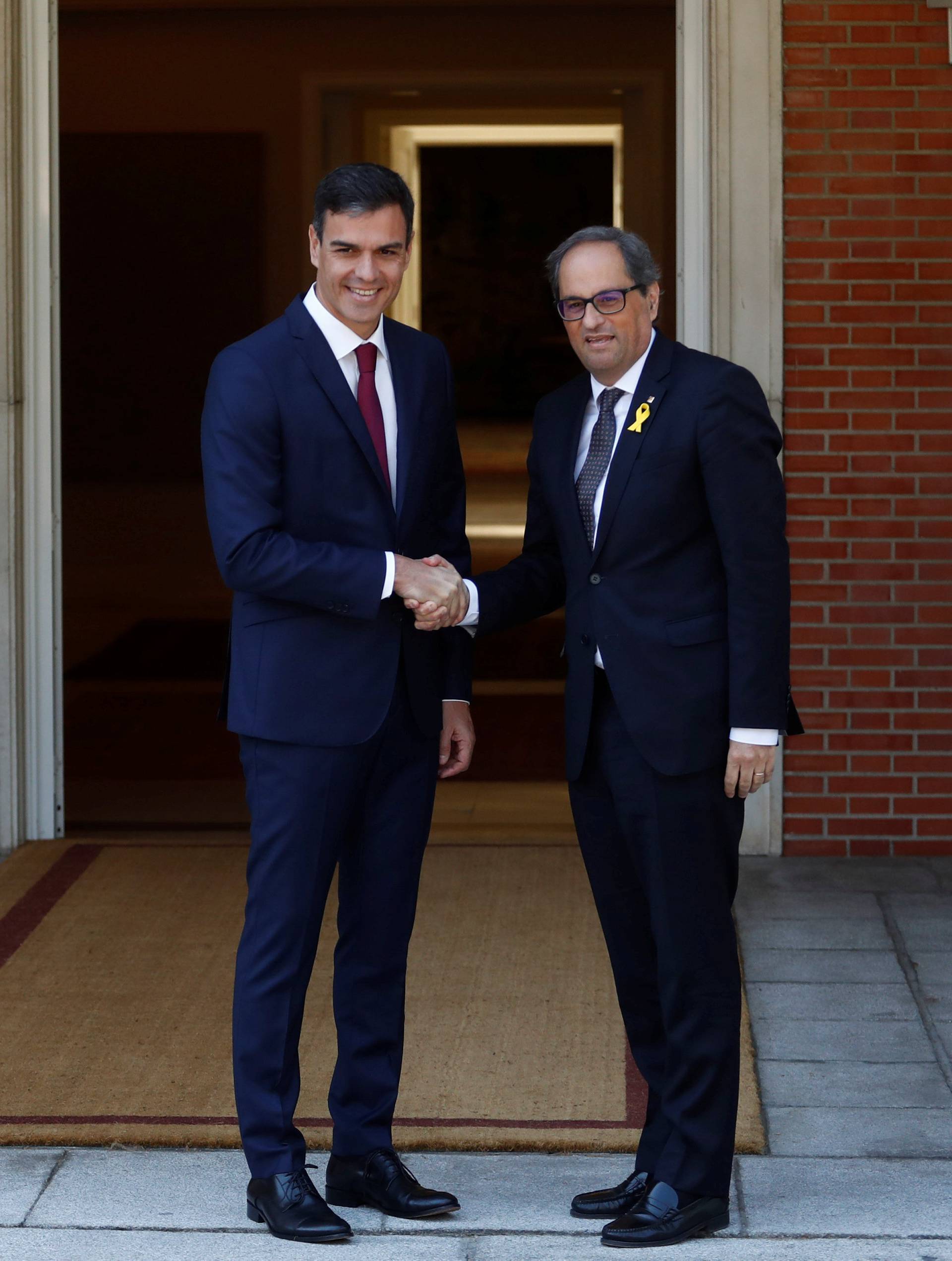 Spain's Prime Minister Pedro Sanchez greets pro-independence Catalan leader Quim Torra at the Moncloa Palace in Madrid