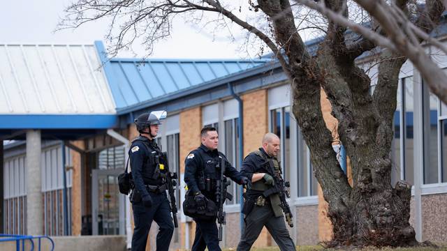 Law enforcement officers work at the scene of a shooting at Perry High School in Perry