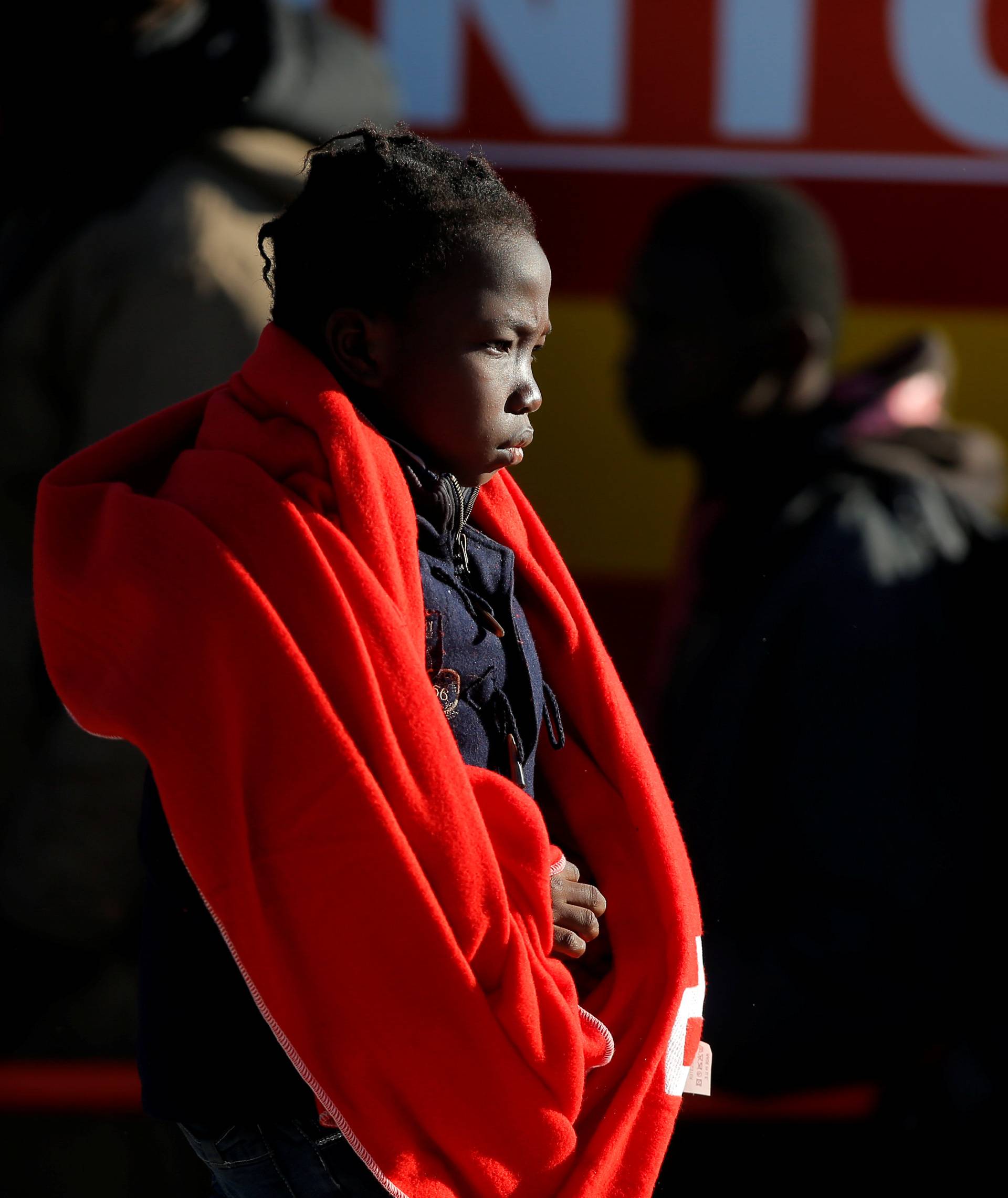 A migrant child walks after disembarking a rescue boat at the port of Malaga