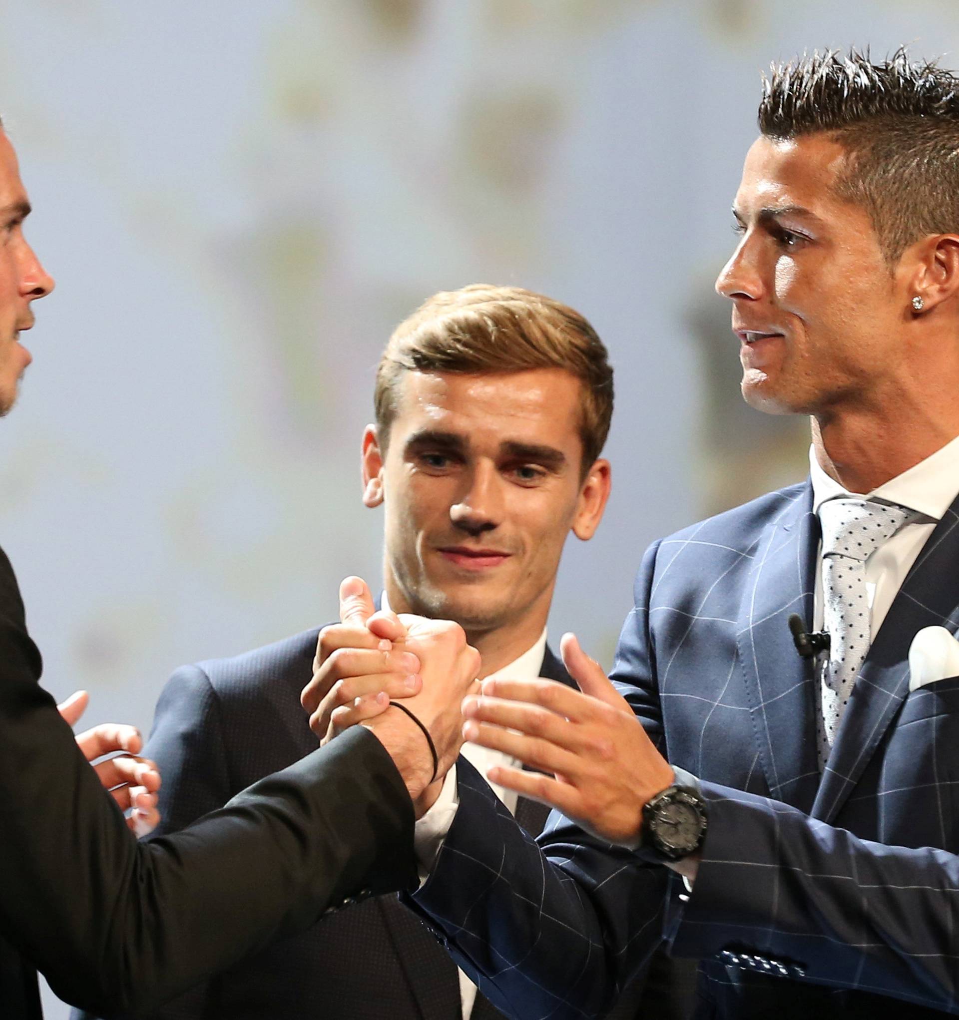 Real Madrid s Ronaldo of Portugal reacts with Bale and Griezmann after he received the Best Player UEFA 2015/16 Award during the draw ceremony for the 2016/2017 Champions League Cup soccer competition