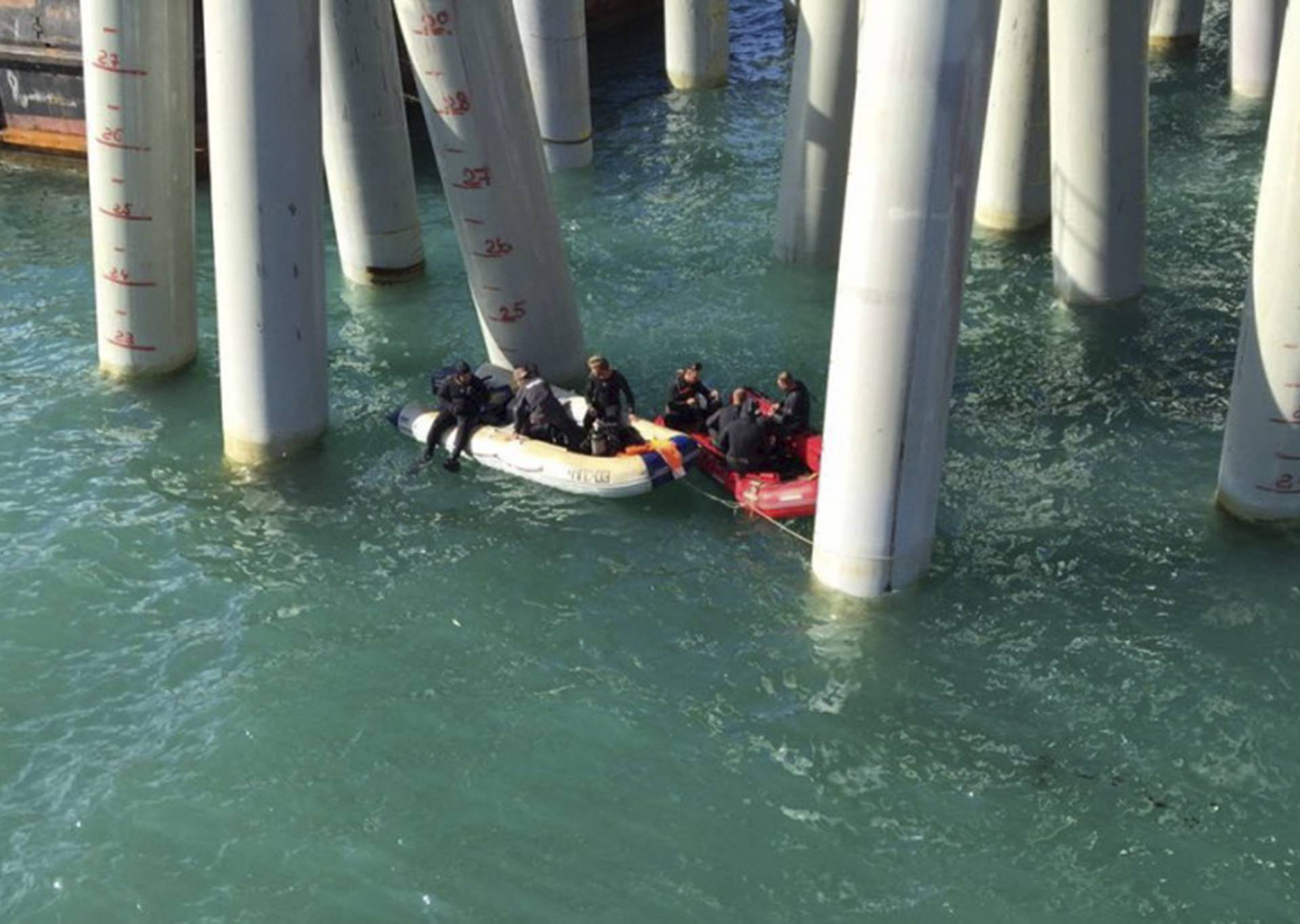 Rescuers work near a pier after a bus carrying a group of workers plunged into the Black Sea in the Krasnodar region