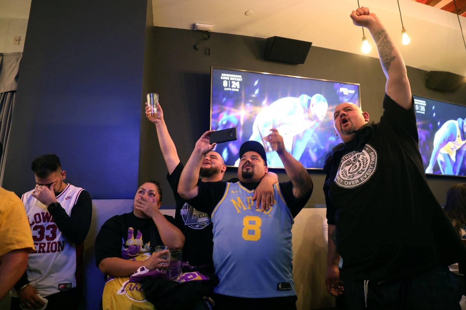 Fans at Tom's Watch Bar react to a tribute to retired basketball star Kobe Bryant and his daughter Gianna