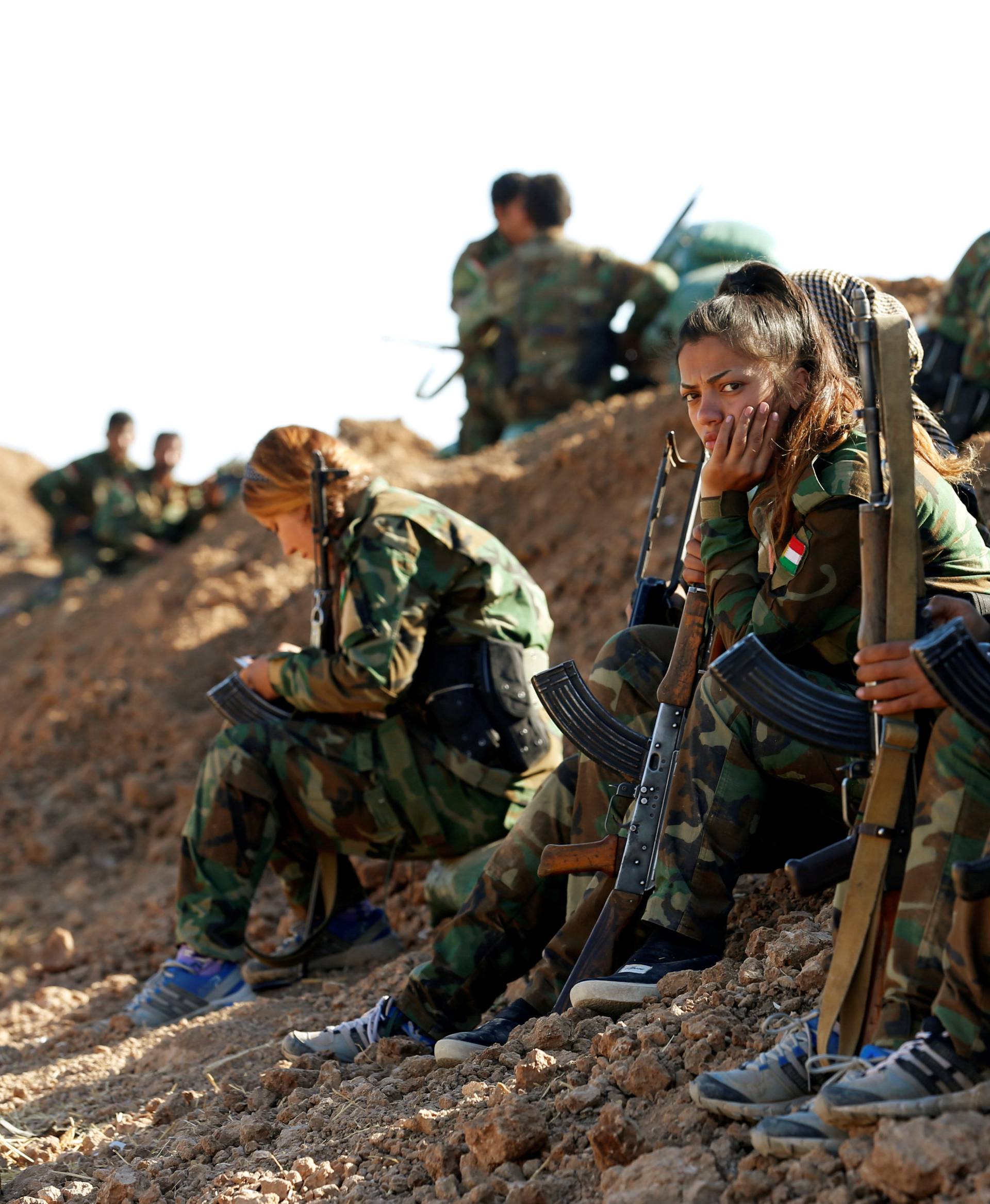 Iranian-Kurdish female fighters sit near a sand berm during a battle with Islamic State militants in Bashiqa, near Mosul