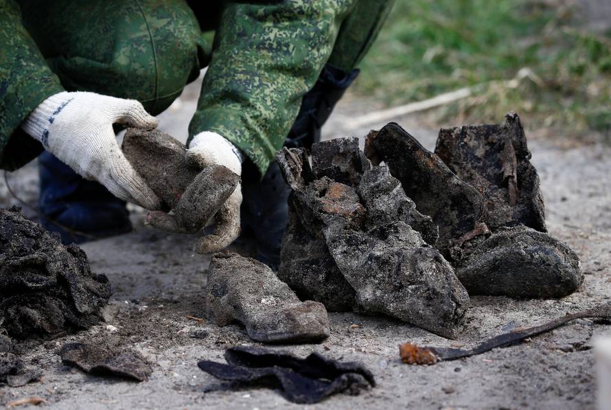 A soldier from a special "search battalion" of Belarus Defence Ministry takes part in the exhumation of a mass grave containing the remains of about 730 prisoners of a former Jewish ghetto, discovered at a construction site in the centre of Brest