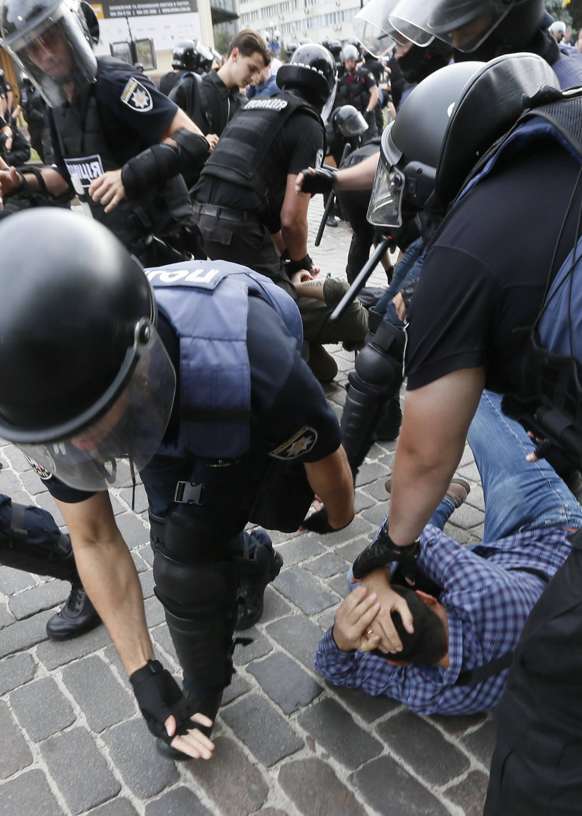 Riot police officers detain an anti-LGBT protesters during the Equality March in Kiev