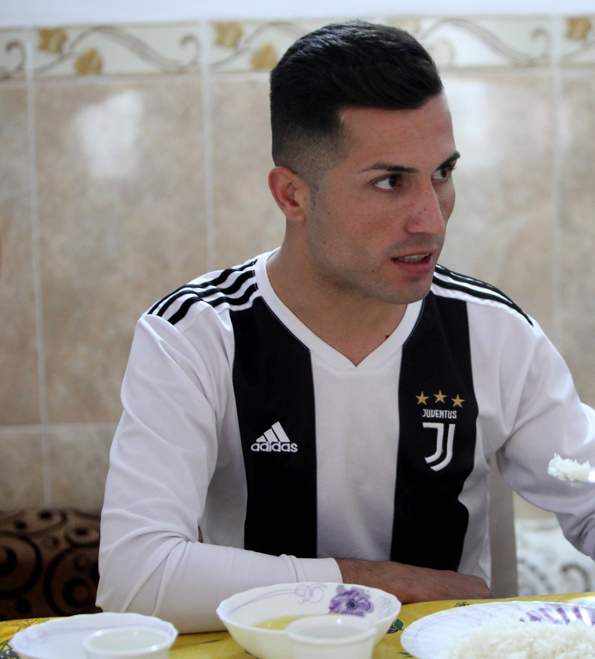 Biwar Abdullah, 25, an Iraqi Kurdish local footballer, who looks like the football player Cristiano Ronaldo, eats at his home in the district of Soran, northeast of Erbil