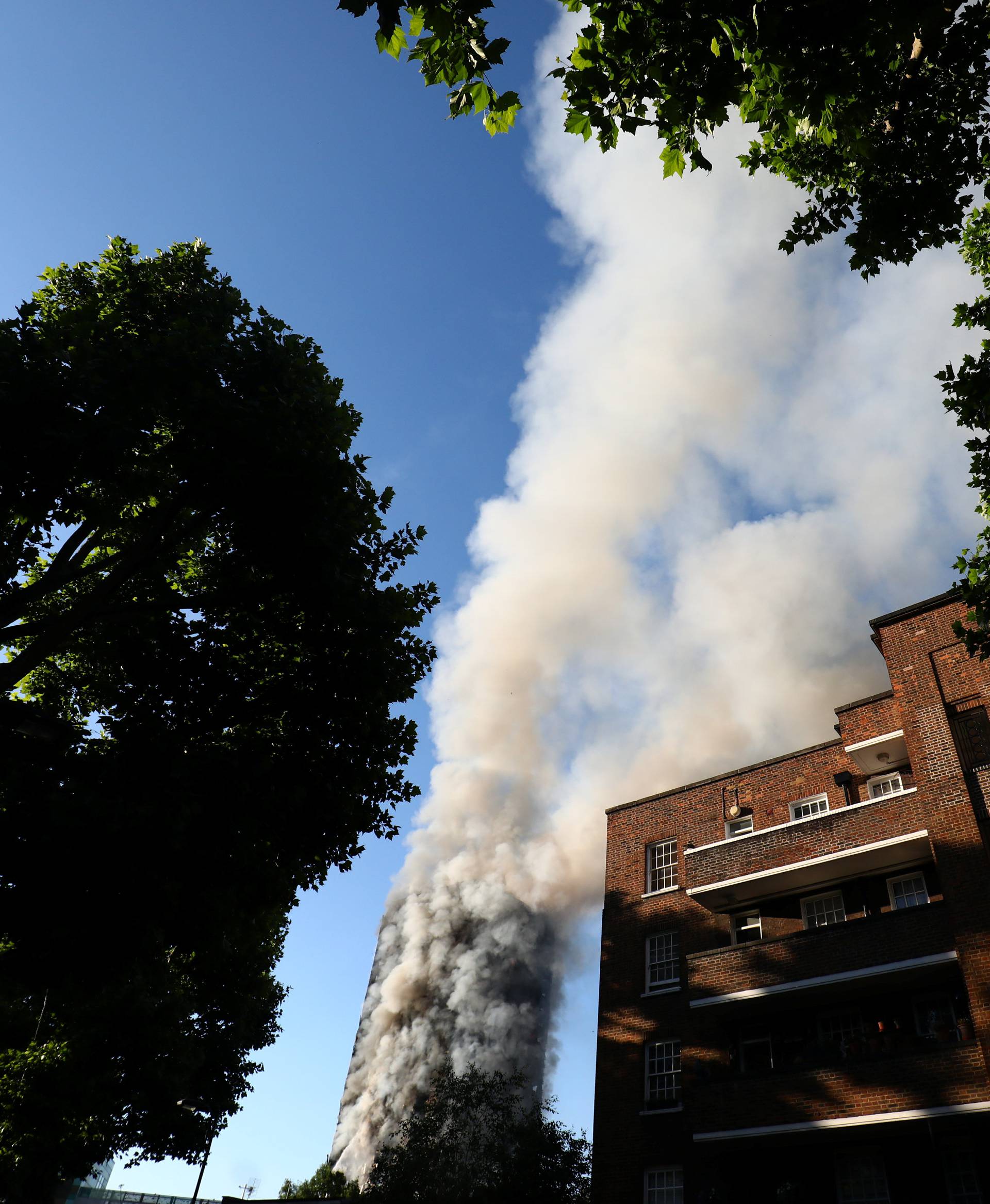 Smoke billows as firefighters tackle a serious fire in a tower block at Latimer Road in West London, Britain