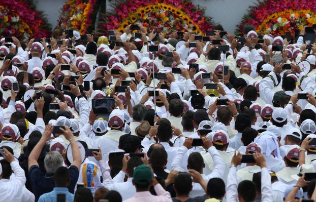 Faithful use their mobile devices as Pope Francis arrives on the popemobile for a holy mass at Enrique Olaya Herrera airport in Medellin