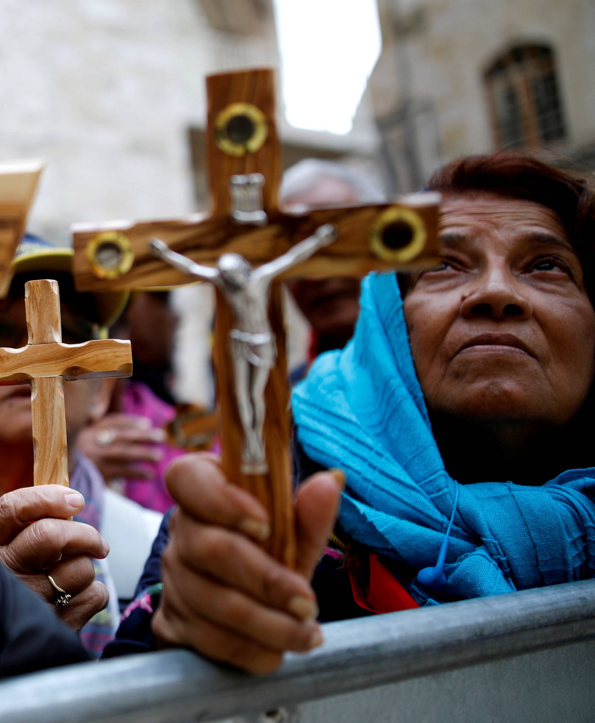 Worshippers hold crucifixes during a Good Friday procession along the Via Dolorosa in Jerusalem's Old City
