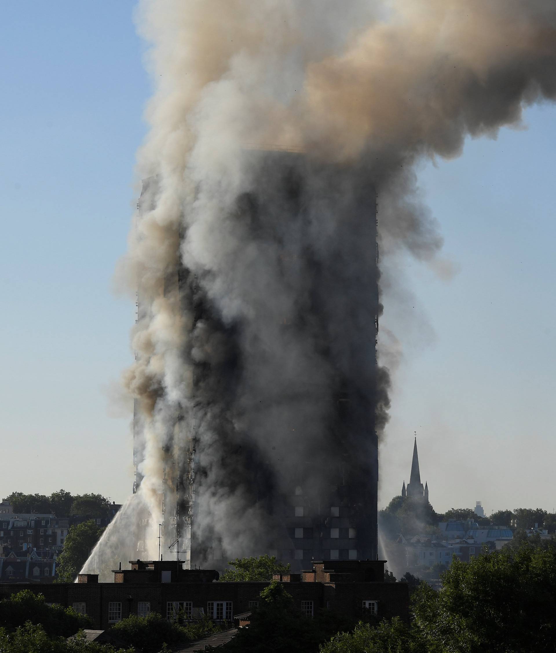 Smoke billows as firefighters deal with a serious fire in a tower block at Latimer Road in West London