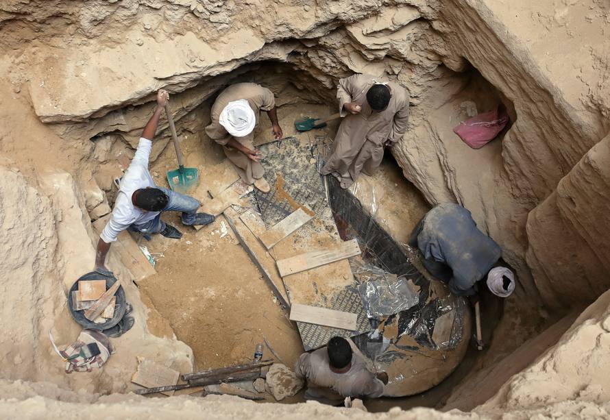 Archaeologists and workers unearth closed coffin containing three mummies with remains of three people in Alexandria