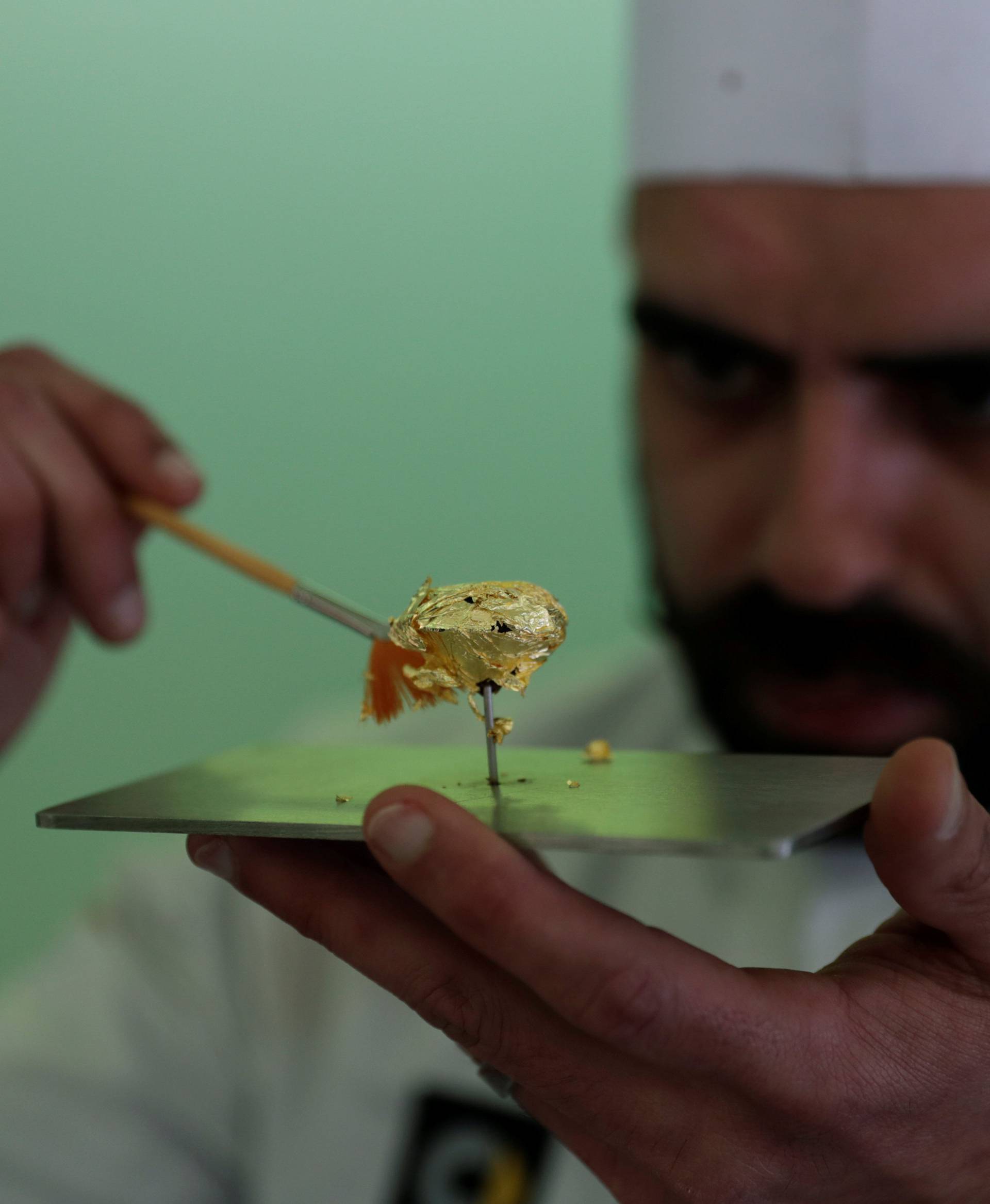Portuguese chocolatier Daniel Gomes prepares a candy wrapped in pure 23 carat gold during international chocolate fair in Obidos
