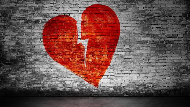 Shape of broken heart on brick wall 