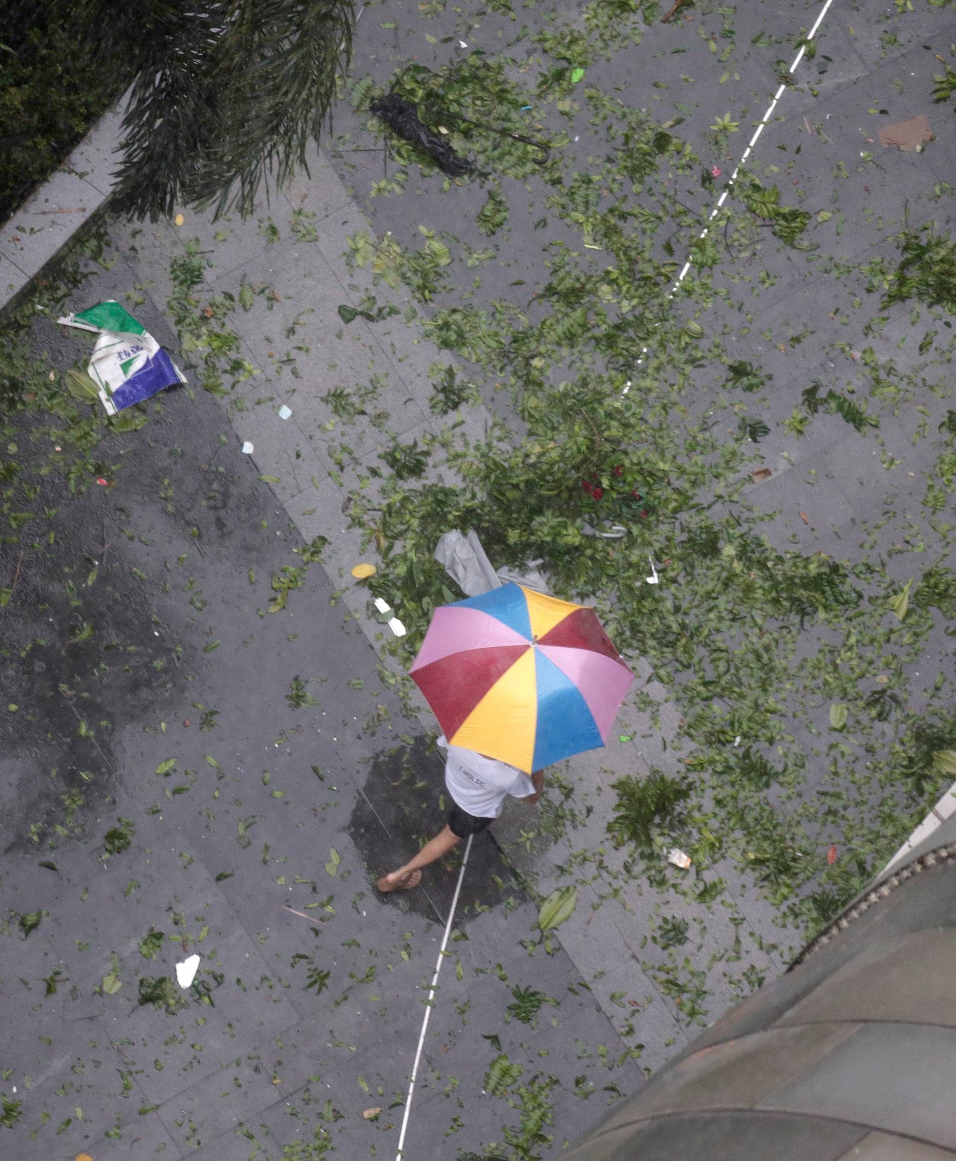 A man holding an umbrella walks in the rainstorm as Typhoon Mangkhut approaches in Shenzhen