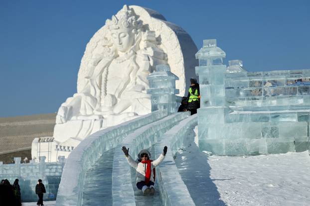 A person slides down an ice slide at the annual Ice and Snow Festival in Harbin