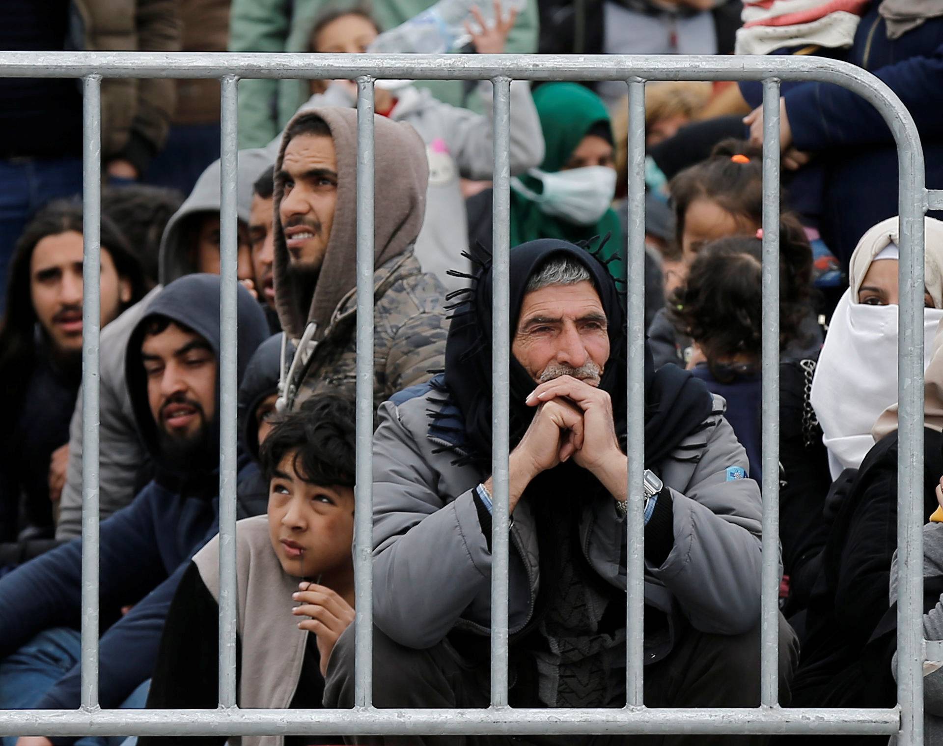 Migrants who arrived on the island of Lesbos in the past four days, are seen at the port of Mytilene, as they wait to board a Greek navy ship, in Mytilene