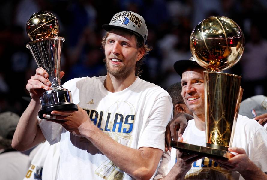 File Photo: Mavericks' Nowitzki holds the Bill Russell NBA Finals MVP trophy as Kidd holds the Larry O'Brien Championship Trophy after their team defeated the Heat to win the NBA Finals basketball series in Miami