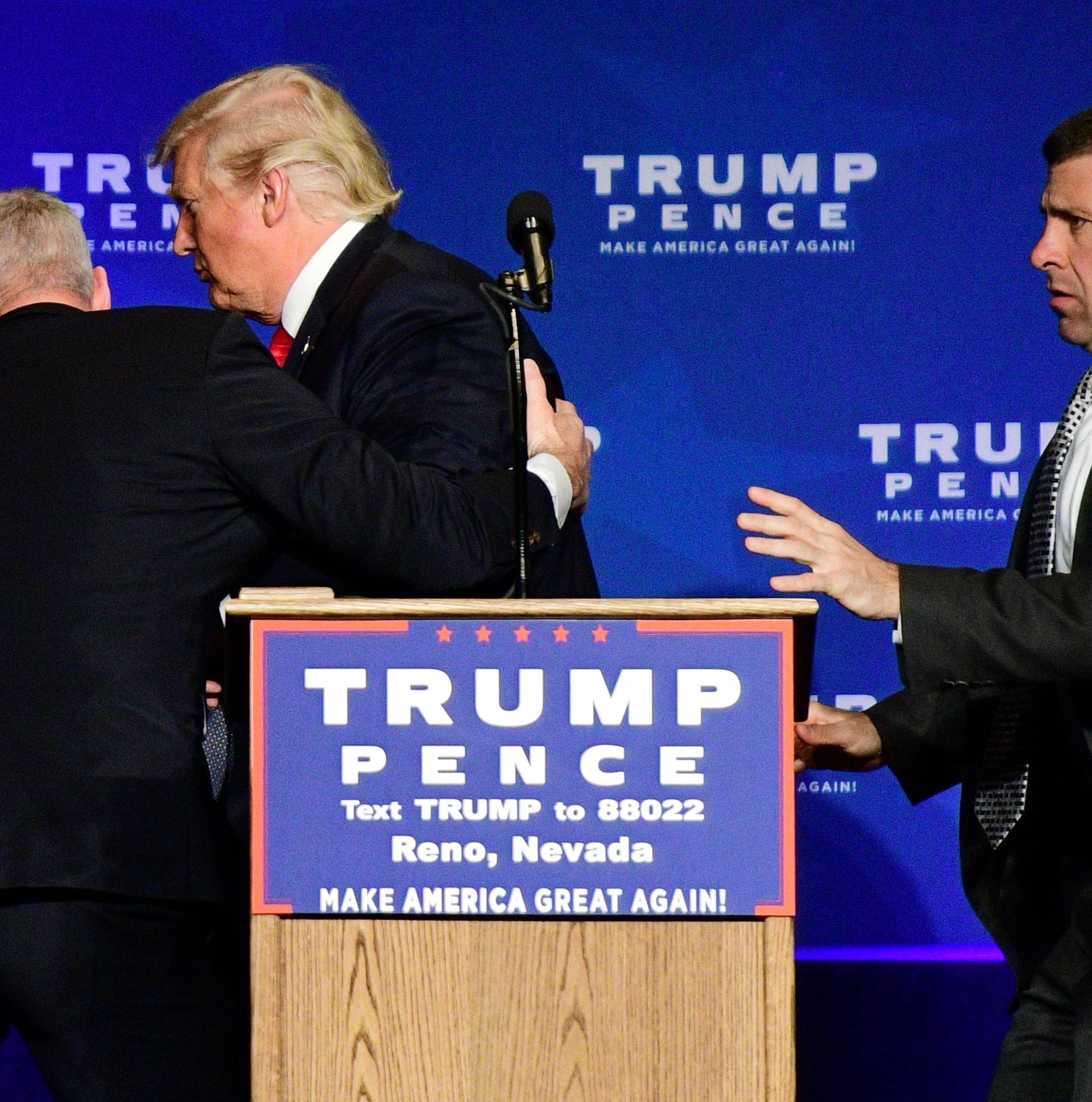Donald Trump is hustled off the stage by security agents in Reno