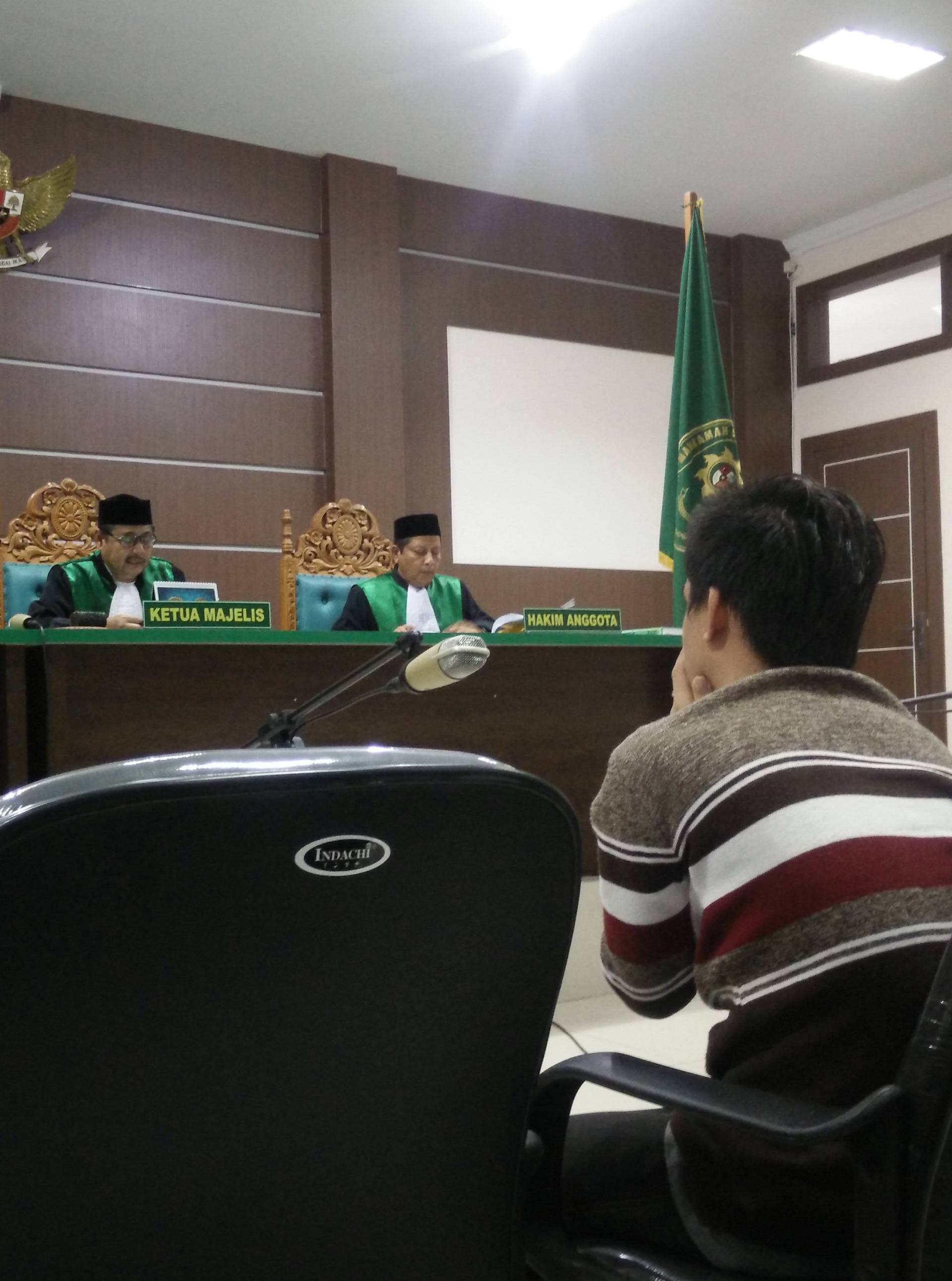 An Indonesian man sits in an Islamic court, one of the two men sentenced to 85 lashes of the cane for having sex together, in Banda Aceh, Indonesia