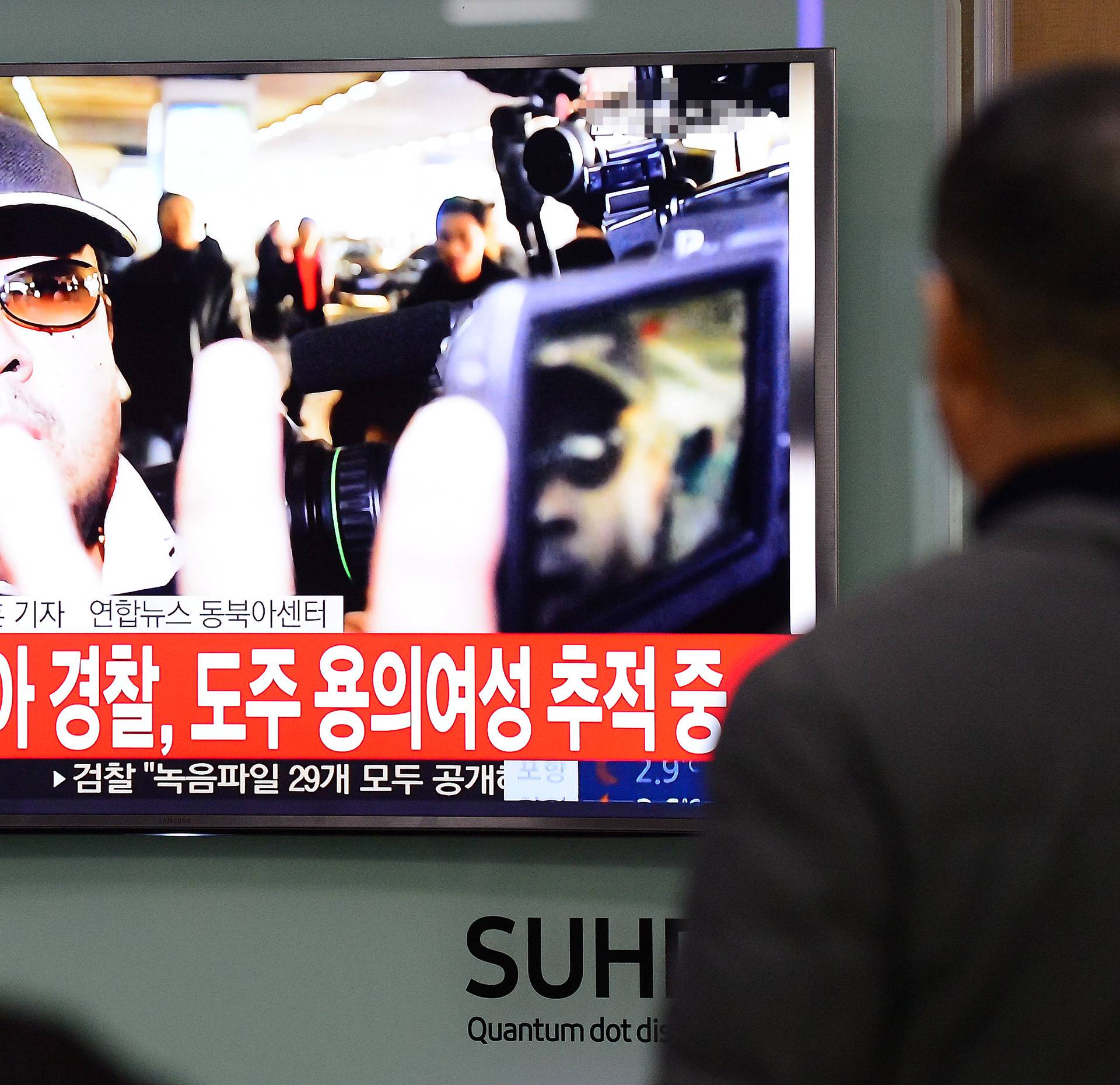 People watch a TV screen broadcasting a news report on the assassination of Kim Jong Nam, the older half brother of the North Korean leader Kim Jong Un, at a railway station in Seoul