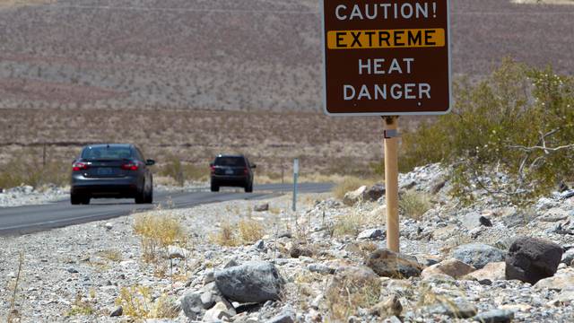 FILE PHOTO: A sign warns of extreme heat as tourists enter Death Valley National Park in California