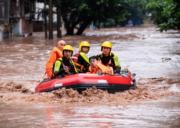 Rescue workers evacuate stranded residents on a flooded street in Chongqing