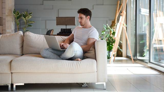 Young man using laptop while sitting in living room