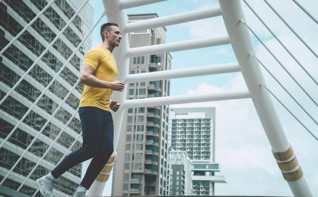Sport fitness man is jogging in modern city morning