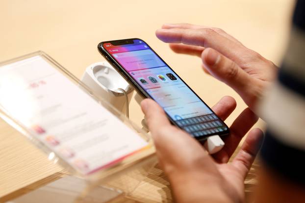 FILE PHOTO: A customer tests the features of the newly launched iPhone X at VIVA telecommunication store in Manama