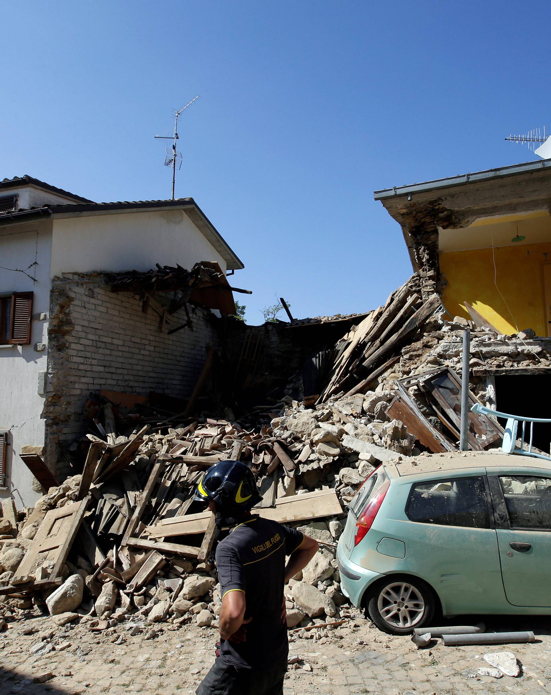 Firefighter inspects collapsed buildings following an earthquake at Castel Sant'Angelo near Amatrice