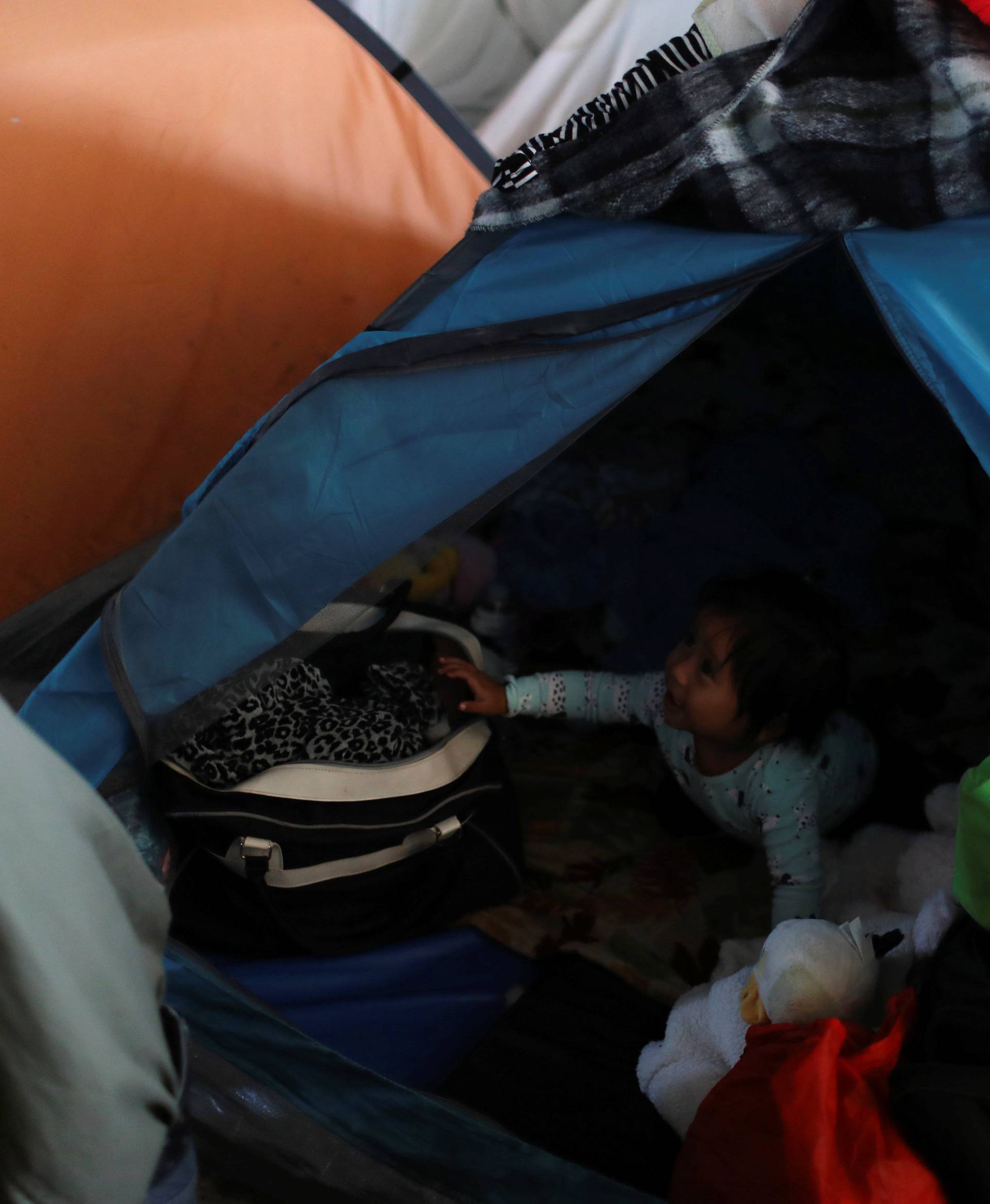 A child, who is part of the Central American migrants moving in a caravan through Mexico and travelling to request asylum in the U.S., is seen inside a tent at a shelter in Tijuana