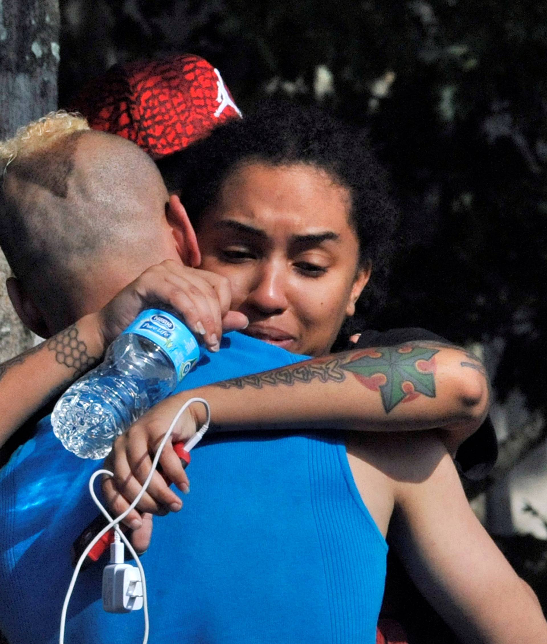 Friends and family members embrace outside the Orlando Police Headquarters during the investigation of a shooting at the Pulse nightclub in Orlando, Florida