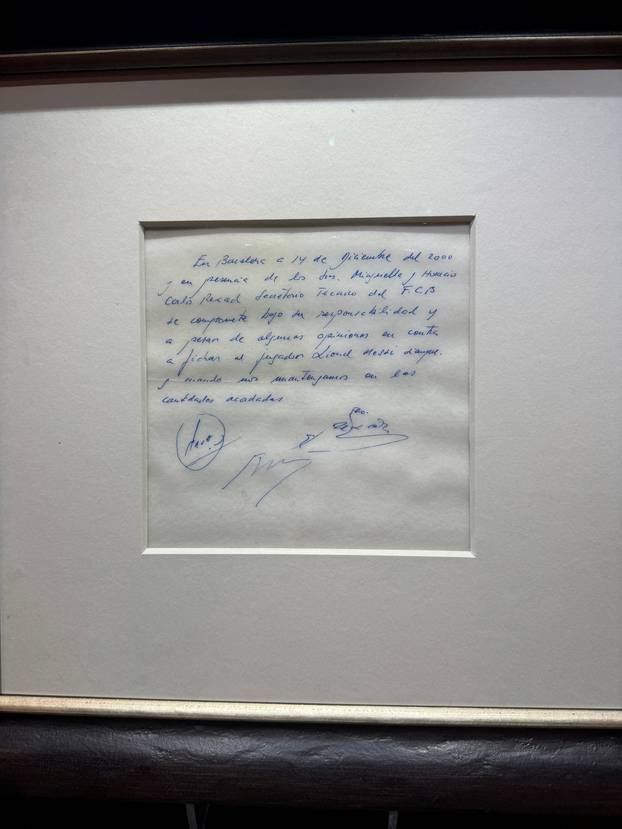 Signed and framed napkin on which soccer club Barcelona promised to sign a 13-year-old Lionel Messi is displayed at the Bonhams auction house in London