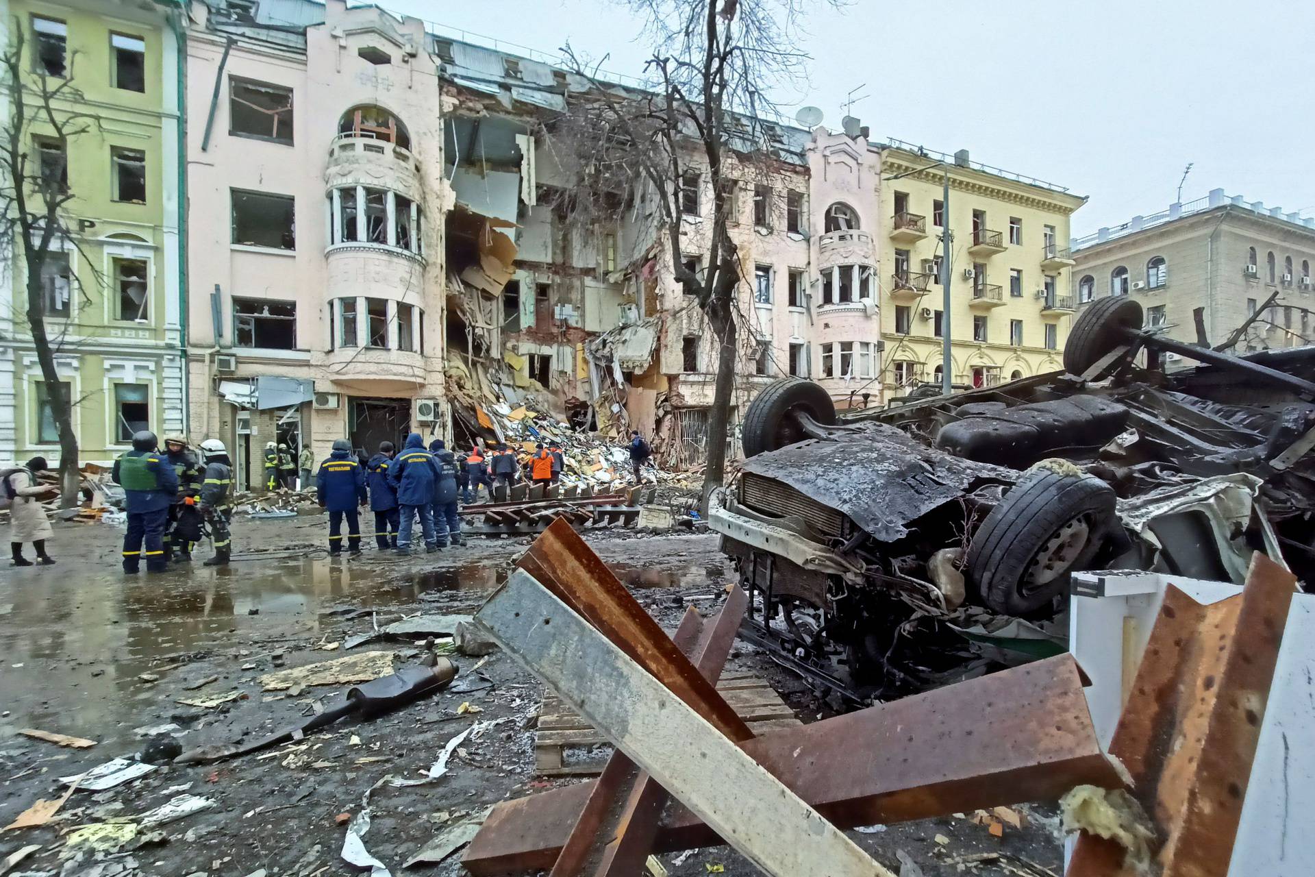 Rescuers work next to a building damaged by air strike in Kharkiv